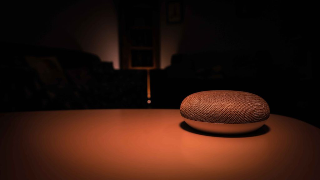 Smart speaker on a table in a dimly lit room