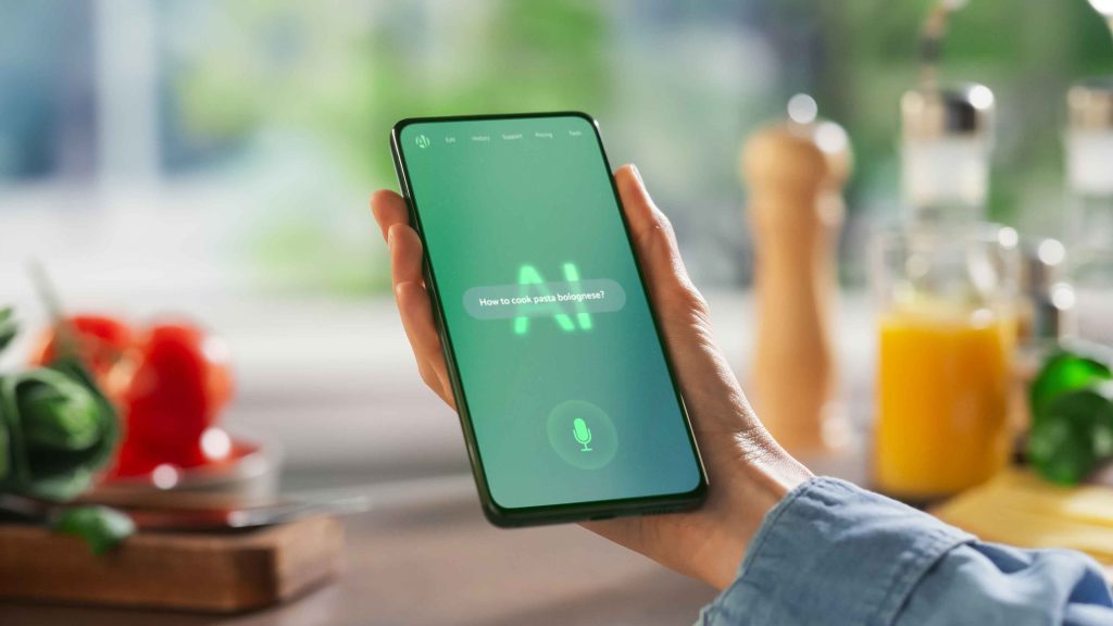 Smartphone displaying an AI voice assistant interface in a kitchen setting