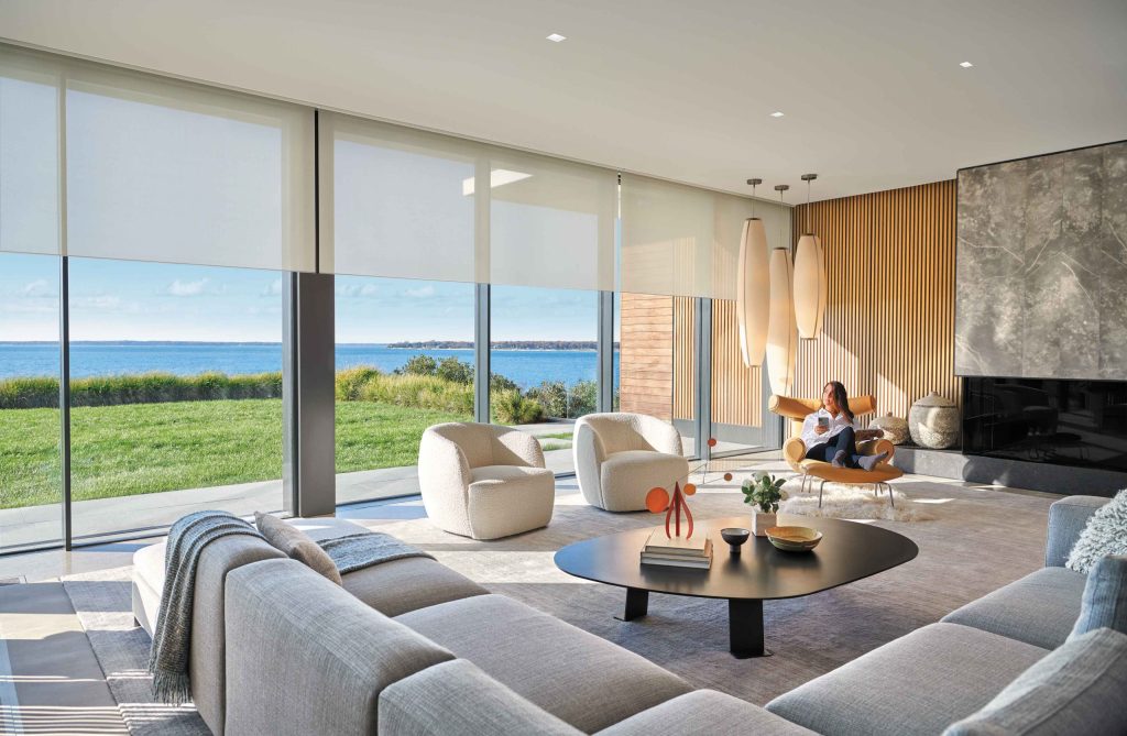 Modern living room with ocean view and motorized shades filtering daylight
