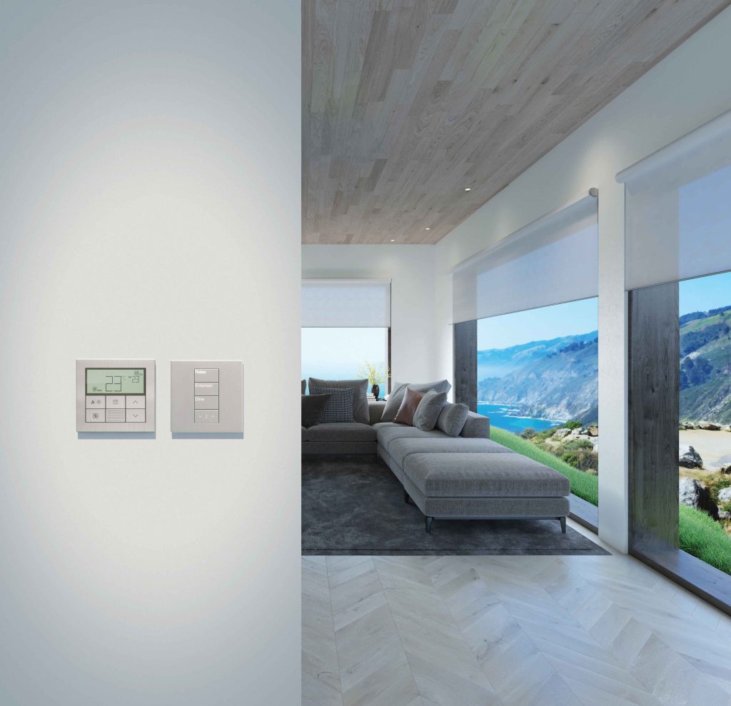 Wall-mounted thermostat and keypad beside a modern living room with ocean view