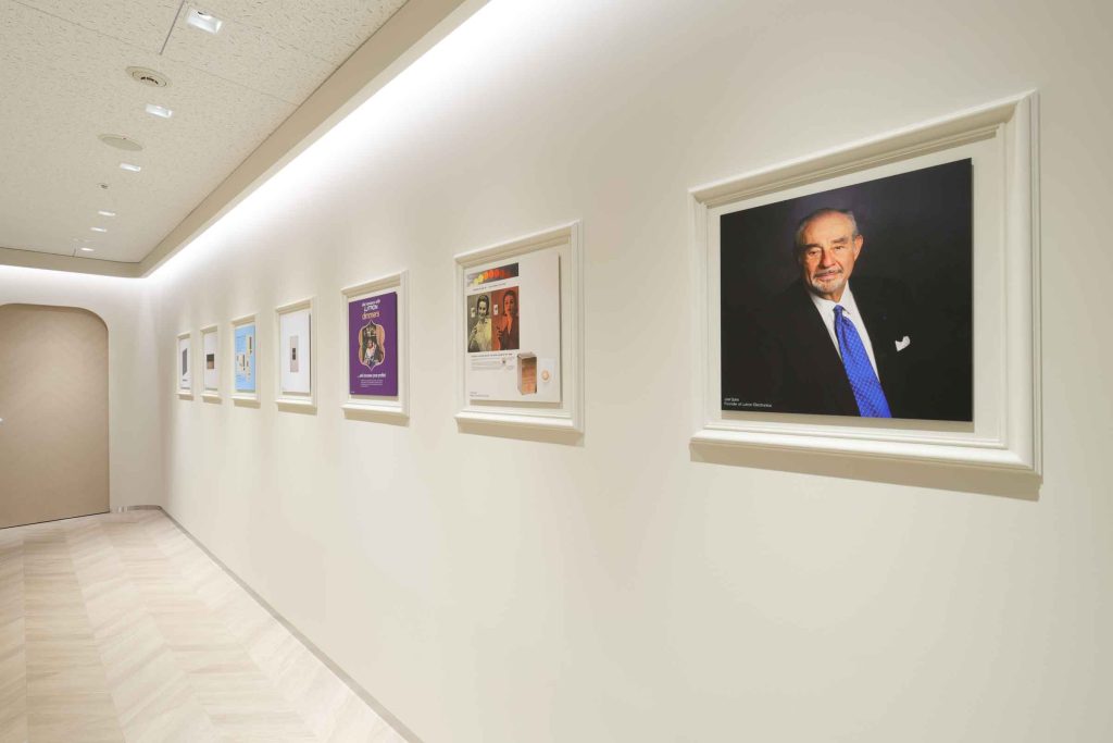 Hallway display of framed Lutron history and portraits