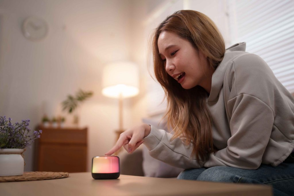 リビングでスマートスピーカーを使って住まいを操作する女性のイメージ