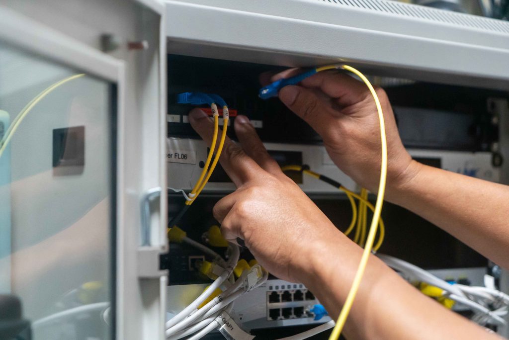 ネットワーク機器にLANケーブルを接続する施工イメージ。スマートホーム時代の高級住宅では、Wi-Fiだけでなく有線LANや情報盤の設計も重要になる。