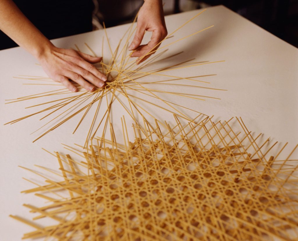 京都の職人が真竹を編み込みコロールランプの構造を制作する様子