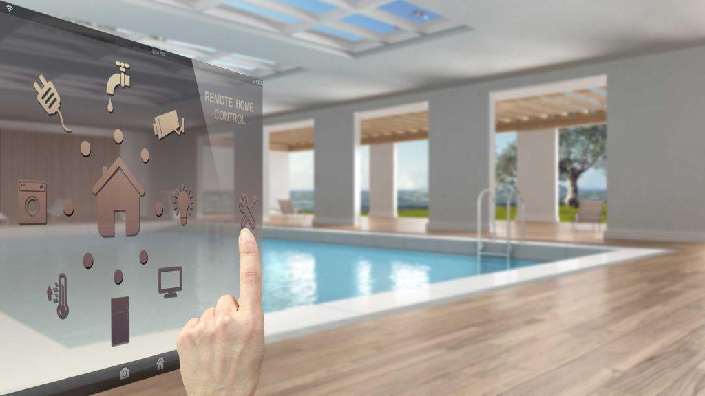 プール付き高級住宅でスマートホーム機能を操作するイメージ。照明、空調、セキュリティ、設備制御をネットワークで統合している。