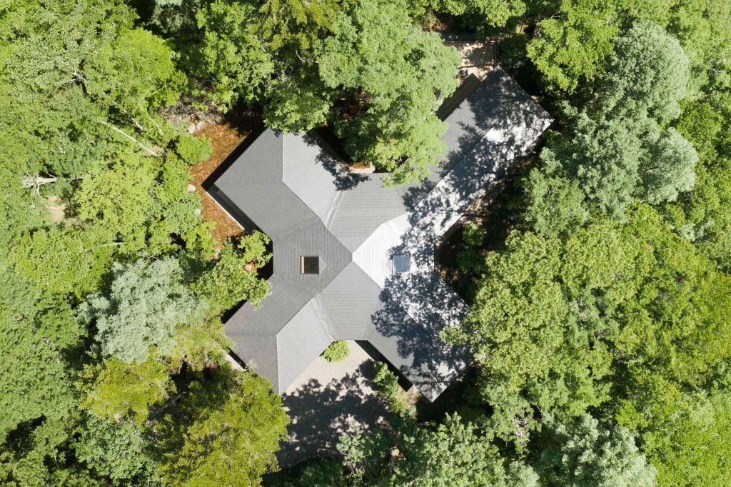 森の中に配置された別荘建築を上空から見た写真