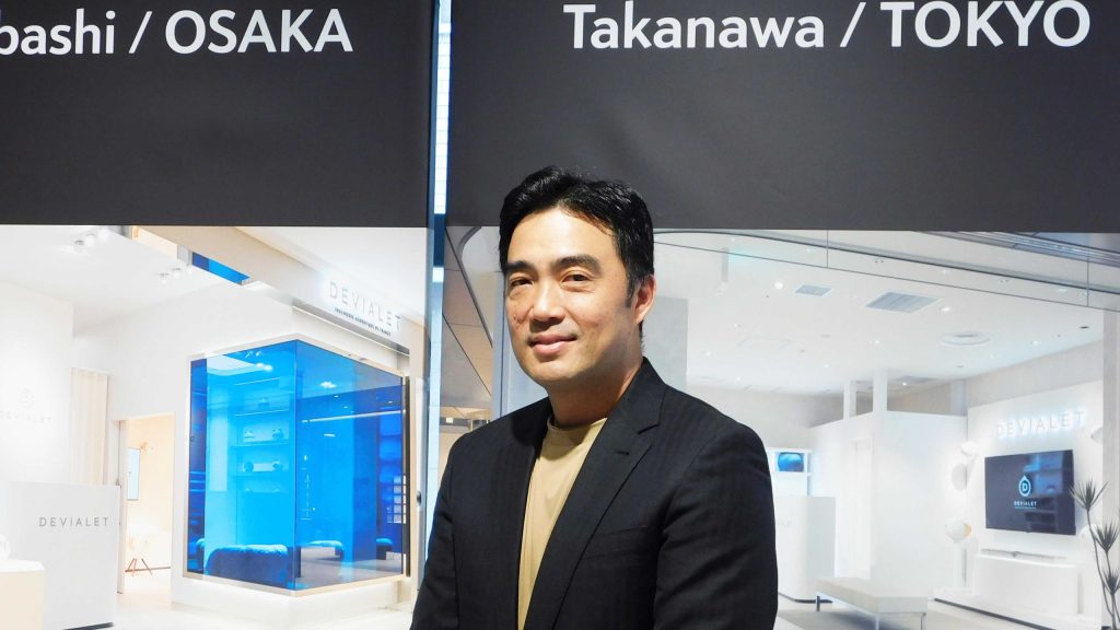 DEVIALET クオーツ心斎橋店と高輪店のパネル前に立つMartin KU氏