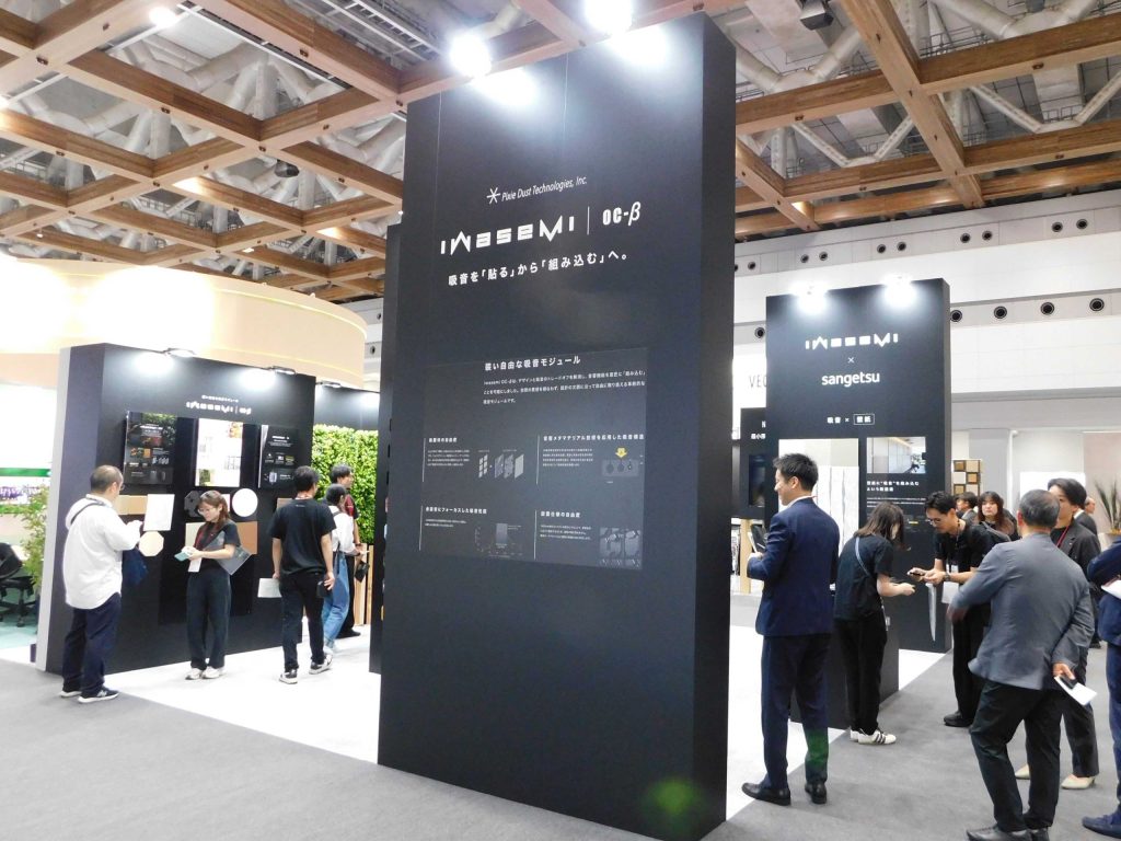 ピクシーダストテクノロジーズのiwasemi OC-βブース。黒い展示壁に吸音モジュールの説明が掲示されている