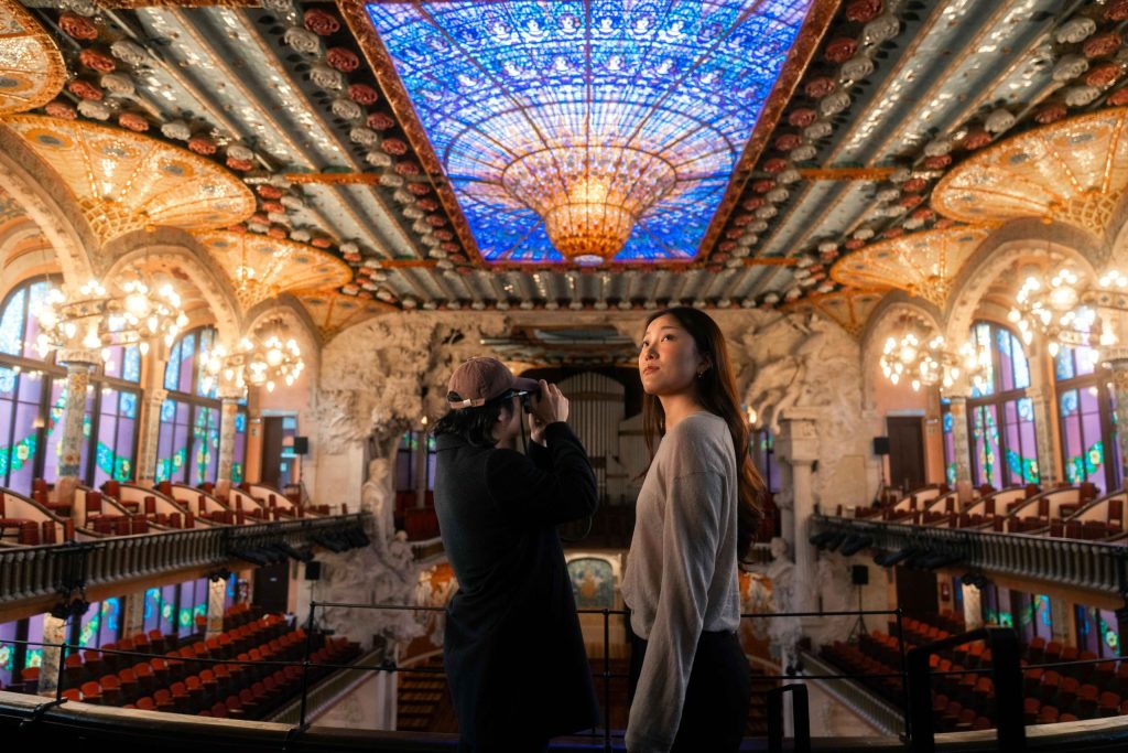 カタルーニャ音楽堂のステンドグラスの天窓を見上げる来館者