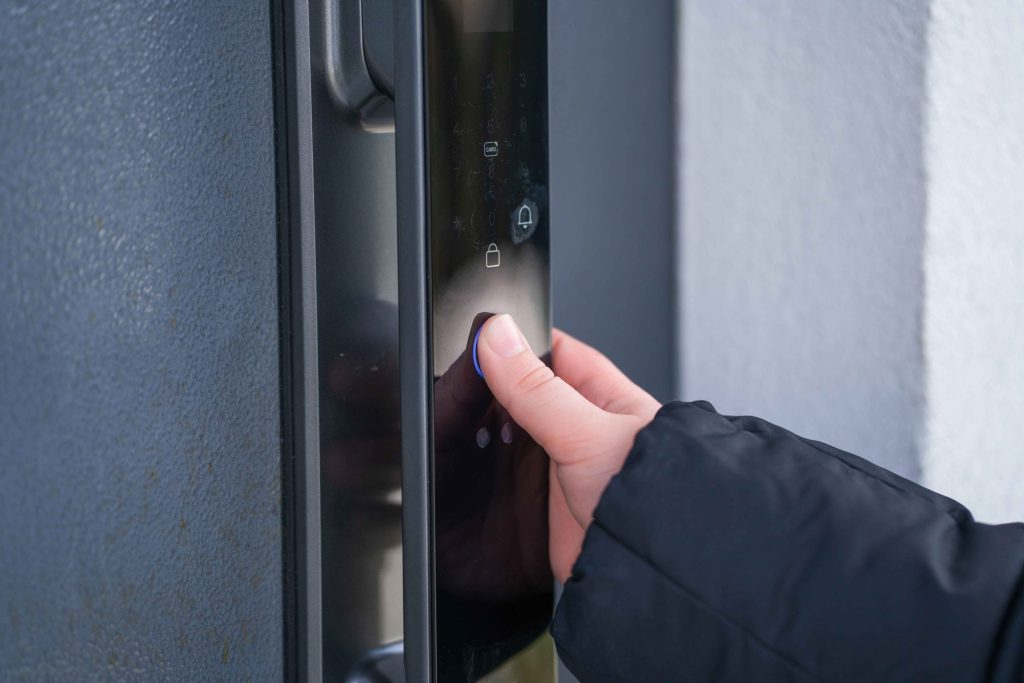 玄関ドアに設置された電気錠を指で操作する様子