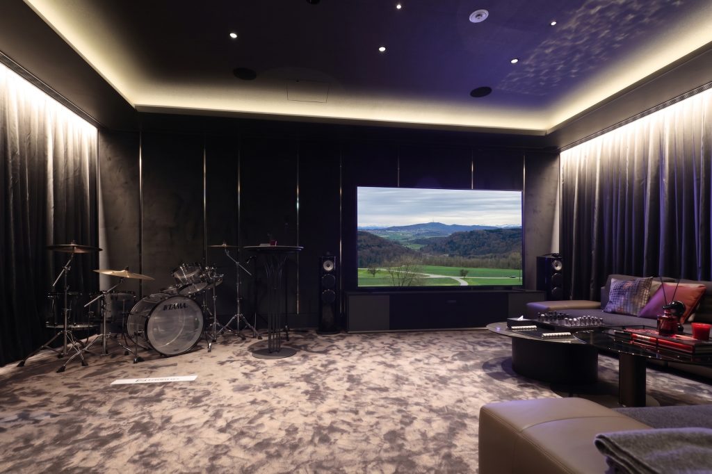 大型映像システムとオーディオ、ドラムセットを備えた専用シアタールーム