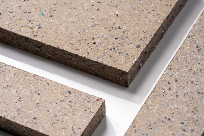 廃棄衣類51%と木質素材49%からつくられたリサイクル建材「PANECO board M」の表面と断面