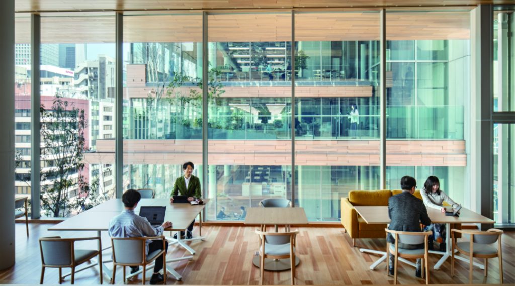 Multi-level timber office architecture with glass facades and interconnected workspaces in Tokyo