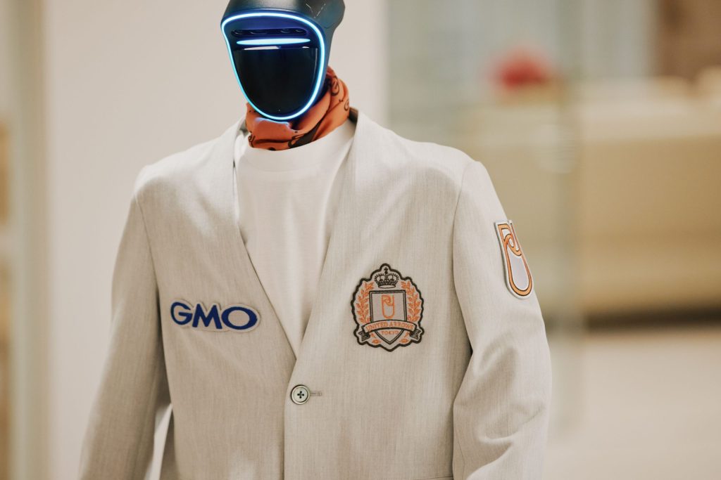 人型ロボットG1向けジャケットの胸元。GMOとユナイテッドアローズのワッペン、オレンジ色のスカーフのディテール